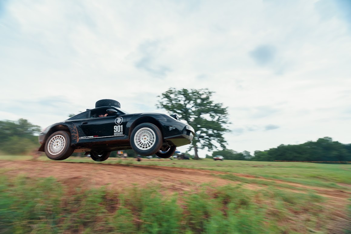 Black 911 Heritage RX airborne over a dirt crest